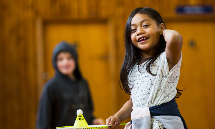 Smiling girl gets ready to play badminton