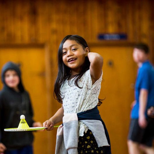 Smiling tamariki prepares to play badminton image