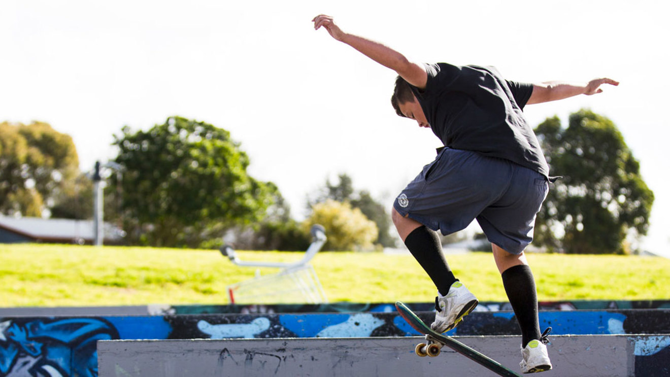 Boy getting air on skateboard at skateboard park