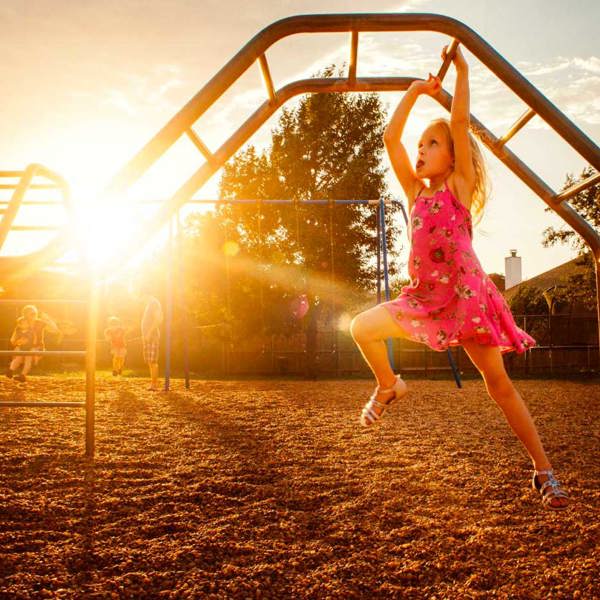 Girl having fun climbing on playground climbing bars