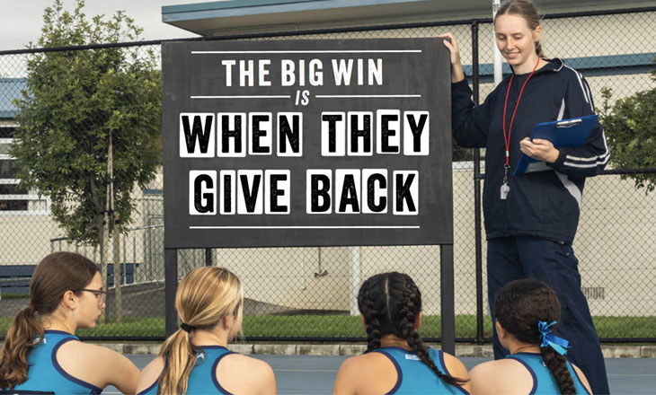 Coach at a blackboard with her netball team
