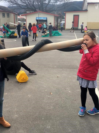 Children on courts playing with cardboard and plastic pipes