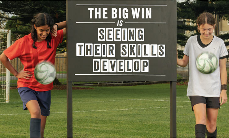 Two girls keeping soccer balls in the air