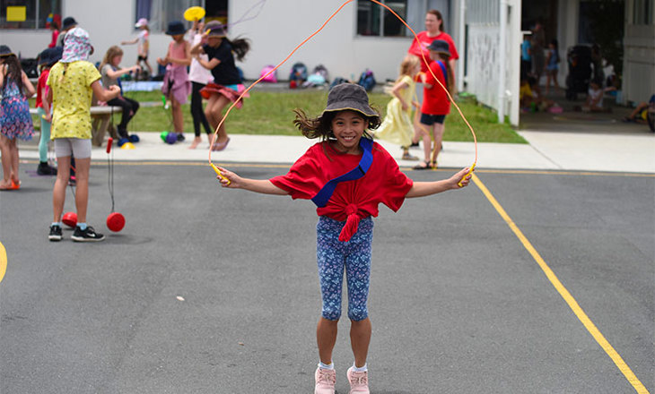 Smiling girl jumps with a skipping rope