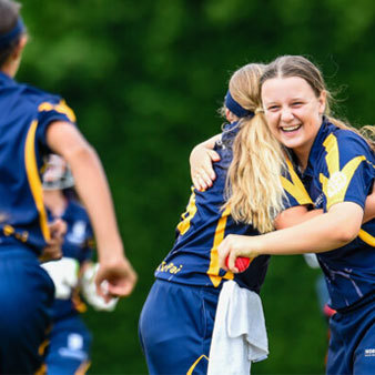 Cricket team embrace on the field
