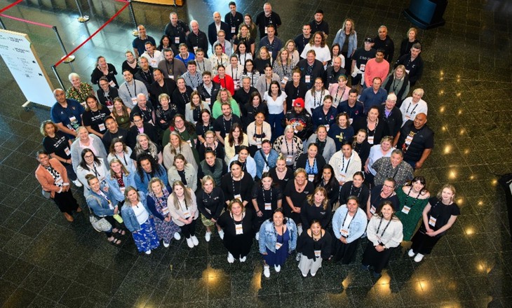 A large group of people standing in a lobby and looking up