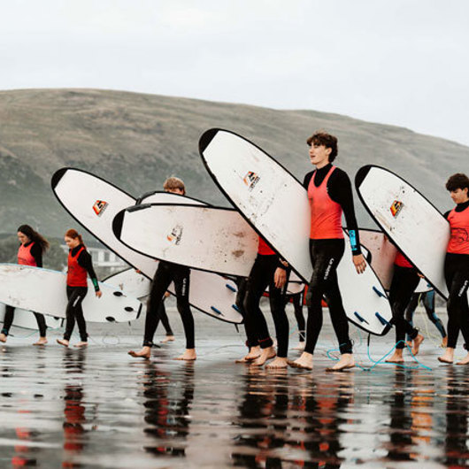 Rangatahi with surfboards on beach