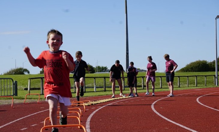 Tamariki running on an athletics track