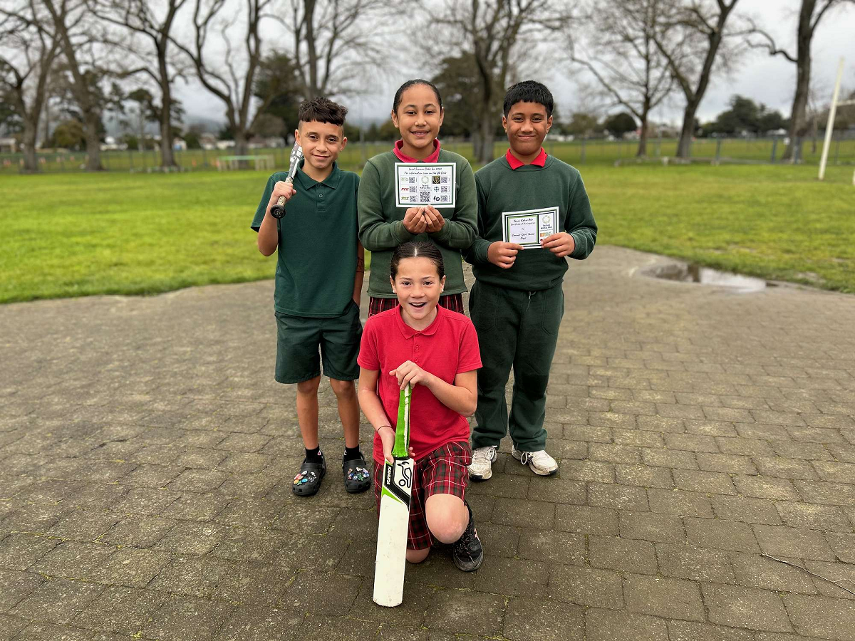 4 Tamariki holding sports equipment and certificate